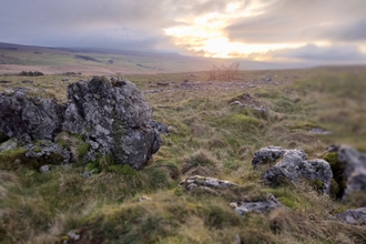 Landscape photograph of a sunset in the Yorkshire Dales with large rocks in the foreground